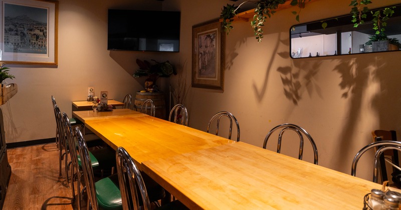Interior, private dining area, long wooden table setup with chairs for 12 people