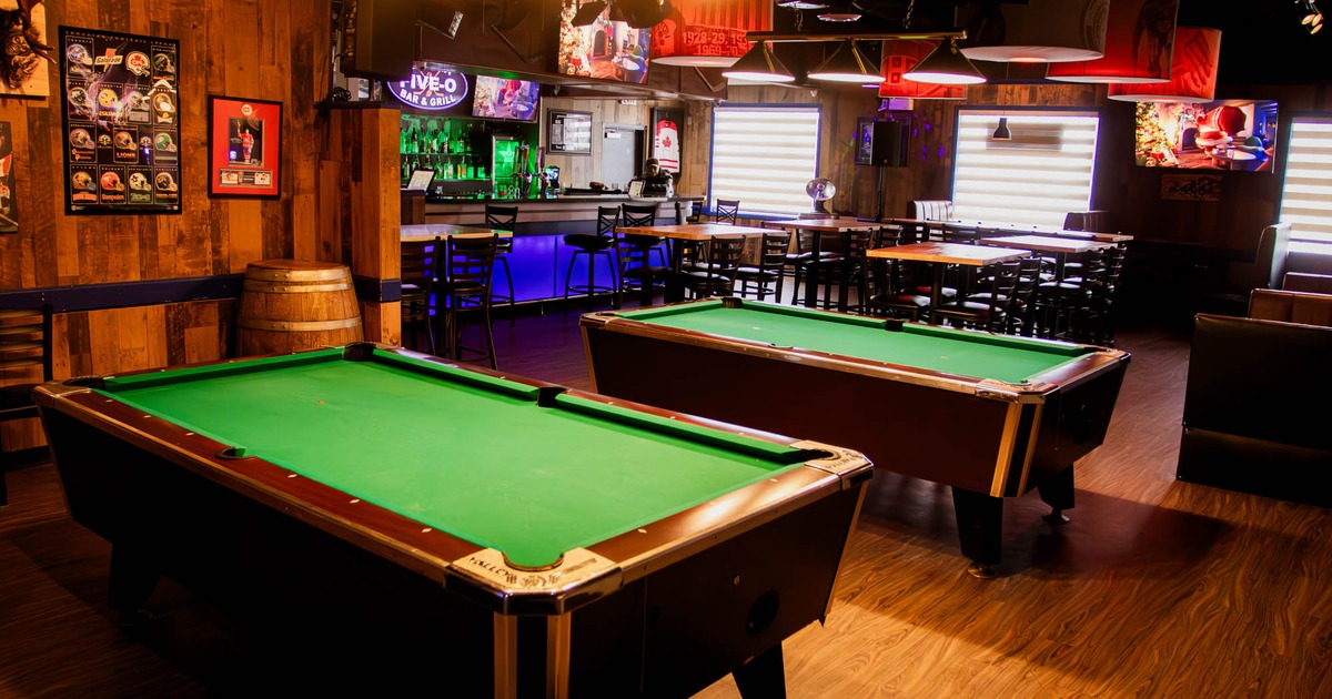 Interior, game room, billiards tables, various framed posters, bar in the back