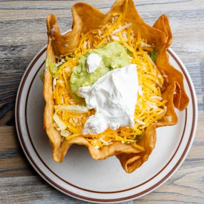 Taco salad served in crispy shell, topped with cheese, guacamole and sour cream.