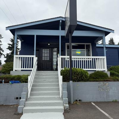 Pub storefront featuring a dark blue exterior with white railing on the porch.