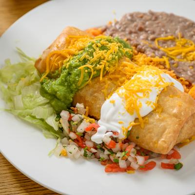 Chimichanga with guacamole, sour cream, cheese, tomato salsa, rice, and beans.