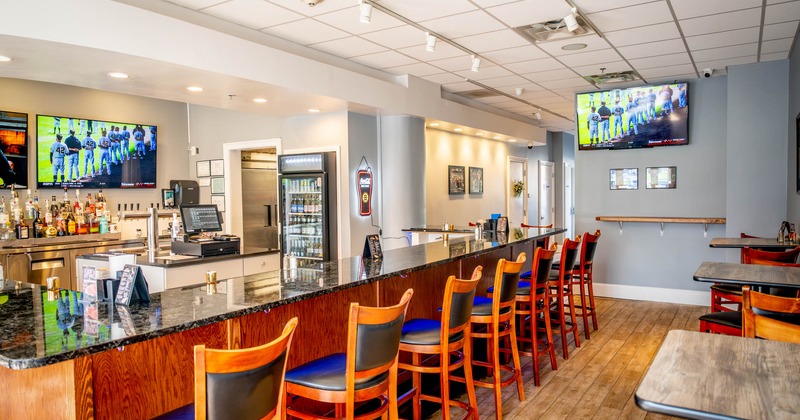 Interior, bar seating area with TVs on the wall