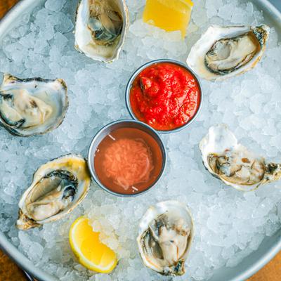 Fresh oysters on ice with cocktail sauce and horseradish.