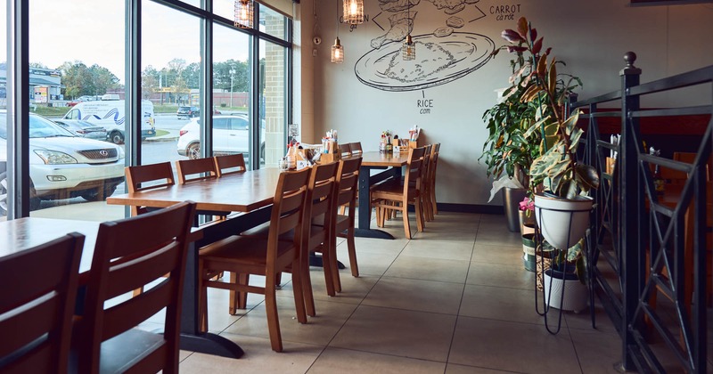 Interior, dining area, wooden top tables with wooden chairs for six, large shop window