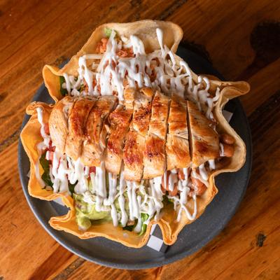 Taco salad with grilled chicken, served in a tortilla bowl.
