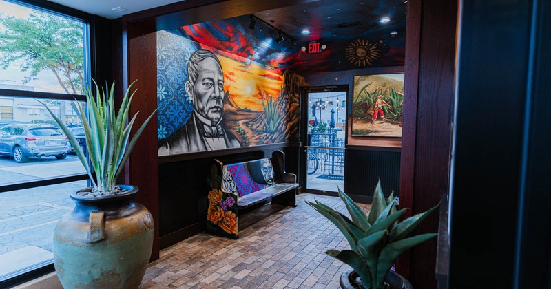 Interior, lobby space decorated with mural art and agave plants