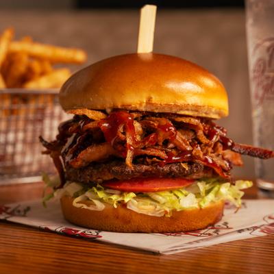BBQ burger with lettuce, tomato, and crispy onion strings.