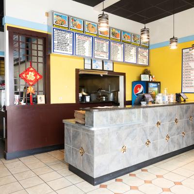 Restaurant counter with menu boards and pendant lights.