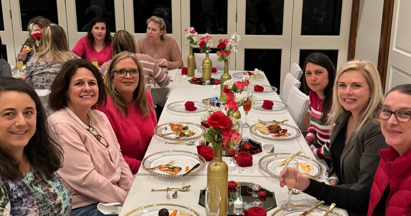 Guests dining at a table with food and flowers