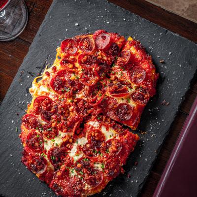 Italian meat flatbread topped with cheese and herbs.