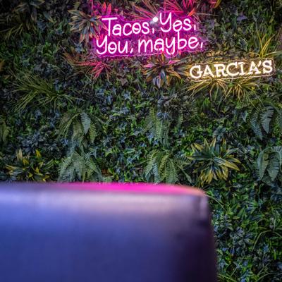 Neon signs on a green leafy backdrop.