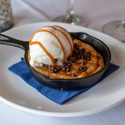 Chocolate chip cookie skillet, topped with ice cream scoop.