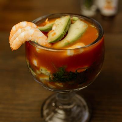 Shrimp cocktail with avocado served in a stemmed glass.