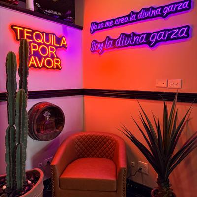 Restaurant corner with neon signs, red chair, cactus, and decorative desert plant.