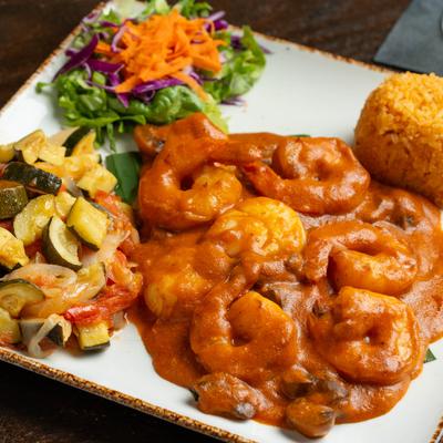 Shrimp in a tomato and mushroom wine sauce served with rice, mixed veggies, and salad.