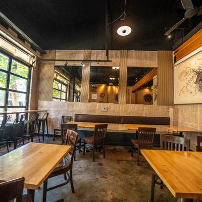 Interior with wooden furniture, large windows and an abstract painting on the wall.