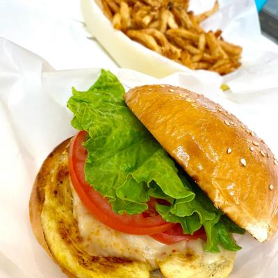 A grilled chicken sandwich served with a side of french fries.
