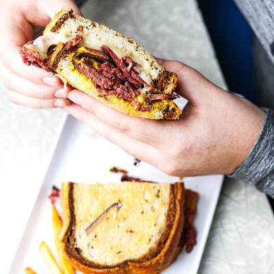 Hands holding a sandwich.