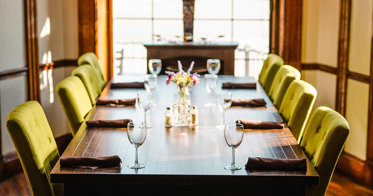 Interior, closeup on a wooden top table for eight, set up and ready for guests