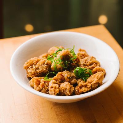 Fried chicken bites garnished with green onions.