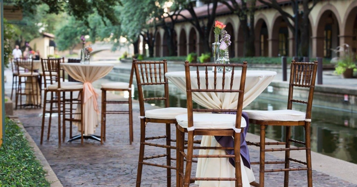 Outdoor seating area with decorated high-top tables and stools