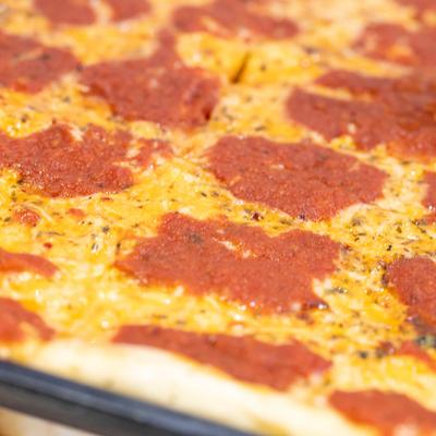 Pizza with tomato sauce and cheese, closeup.