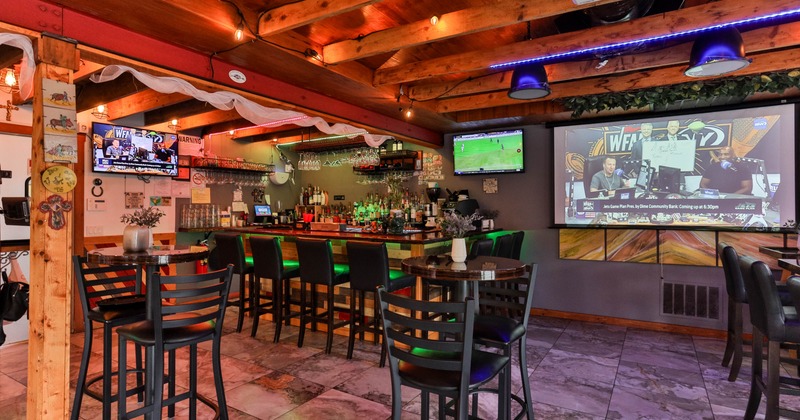 Interior, tables and chairs, bar and bar stools in the back