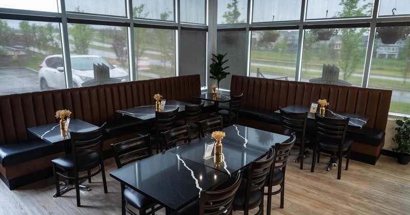 Interior view of a restaurant with booths, tables, and large windows