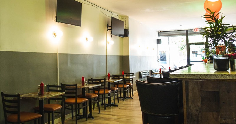 Interior, seating area with tables and chairs, bar on the right