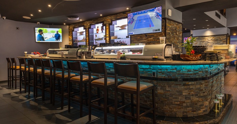 Interior of a modern sushi bar, high barstools lined up in front of the counter