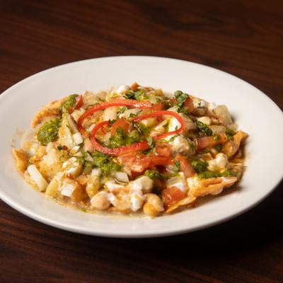 Crispy crackers topped with potatoes, chickpeas, yogurt, chutneys, and fresh herbs.