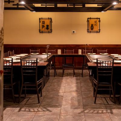 Dining area with set teppanyaki tables and chairs.