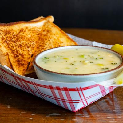 Homemade soup served with grilled cheese sandwich.