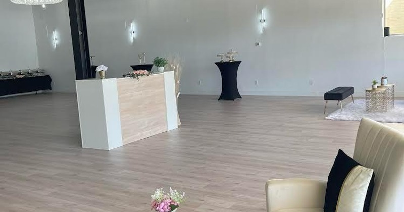 Spacious room with a front desk, cocktail table, seating and catering table in the corner