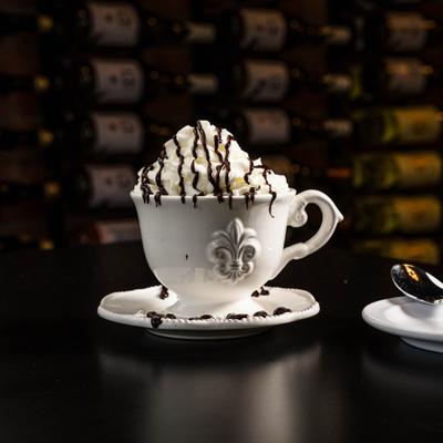 Latte topped with whipped cream and chocolate syrup.
