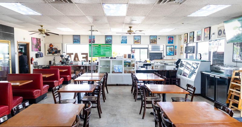 Interior, lined up tables and chairs, bar in the back