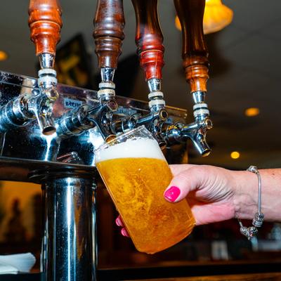 A hand pouring beer from the tap.