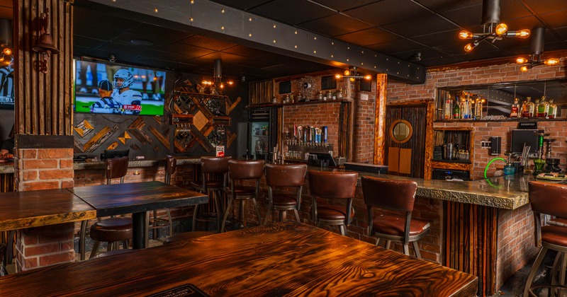 Rustic interior, brick walls, wooden tables, leather bar stools, TV and well-stocked bar