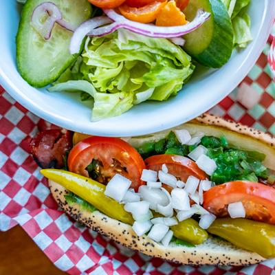 Chicago dog with house salad, top view, close up.