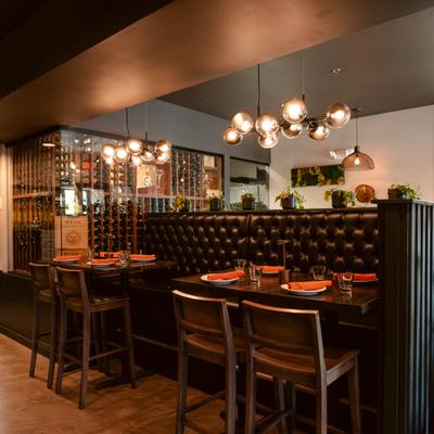 Modern dining booths with pendant lighting wine display.