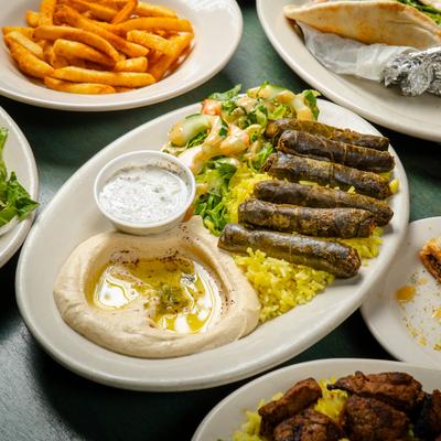 Meat dolma plate surrounded by various food plates.