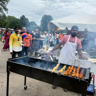 Exterior, an employee preparing grilled skewers.