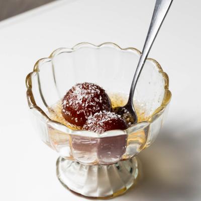 Gulab Jamon served in a glass bowl.