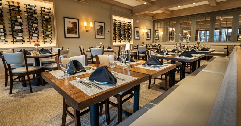 Elegant restaurant interior with neatly set tables featuring black napkins and glasses