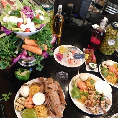 A colorful display of Mediterranean dishes on a black countertop.
