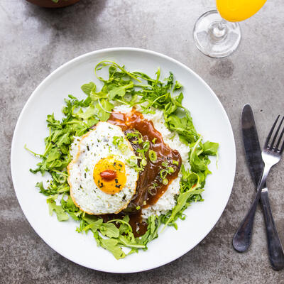 Fried egg, red dip, rice and green decorations on the side