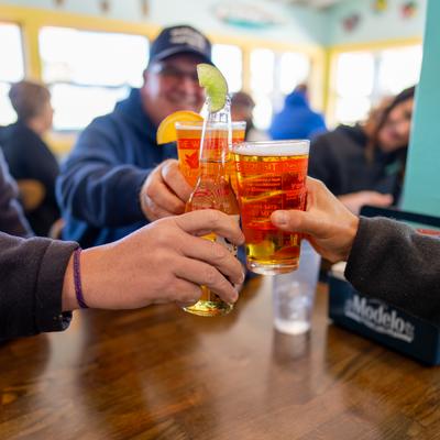 A group of guests toasting with beers at a table.