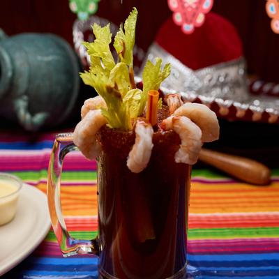 Bloody Mary cocktail with shrimp and celery garnish.