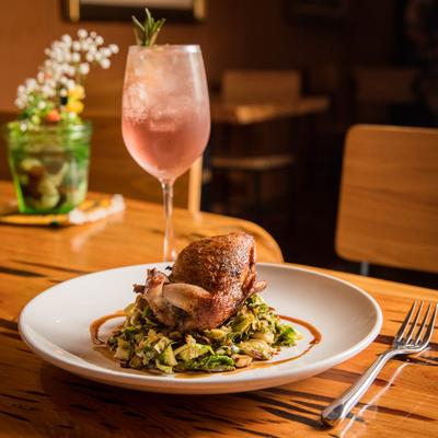 Grilled meat and green salad, cocktail in the back