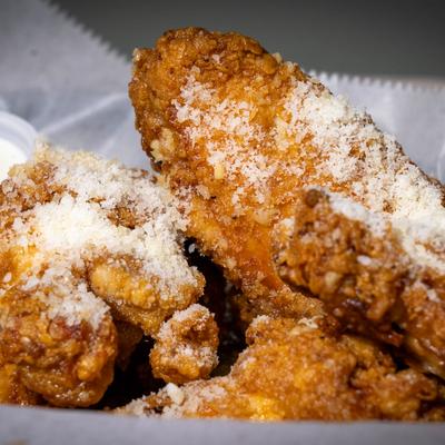 Crispy fried chicken wings topped with grated cheese.